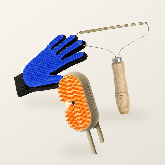 The shed kit: steam brush, blue grooming glove and wood-handled fur lifter arranged on a warm cream background