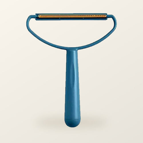 Teal fabric scraper with a brass blade, on a warm cream background