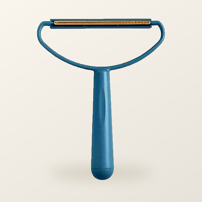 Teal fabric scraper with a brass blade, on a warm cream background