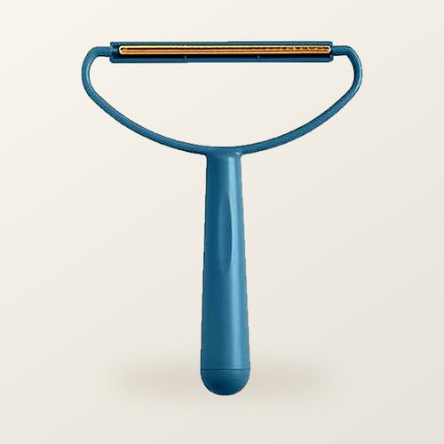 Teal fabric scraper with a brass blade, on a warm cream background