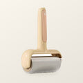 Wide sticky lint roller with a cream bear-shaped handle and a ten centimetre drum, on a warm cream background